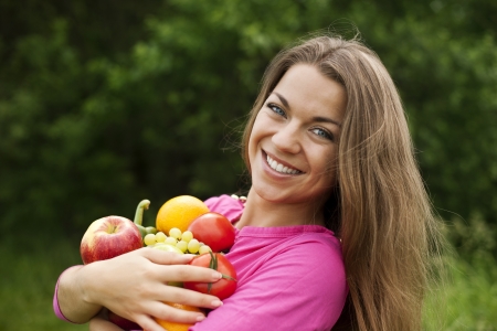 Young woman holding fruits and vegetablesの写真素材