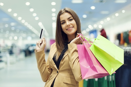 Young woman with credit card and shopping bagの写真素材
