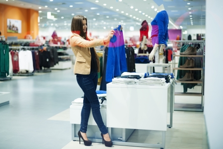 Attractive woman choosing cloths in shopの写真素材