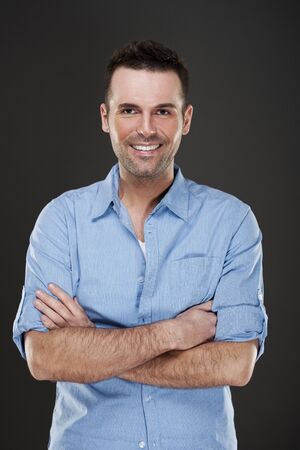 Cheerful man smiling with arms crossedの写真素材