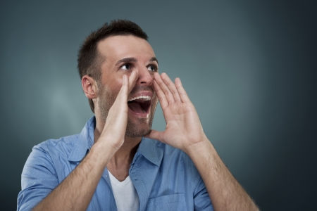 Handsome man shouting through hands Handsome man shouting through hands