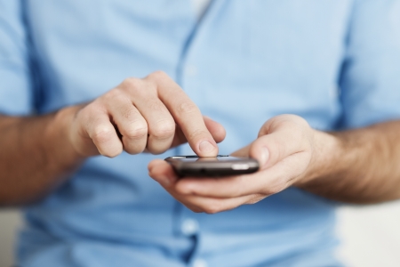 Man texting on mobile phoneの写真素材