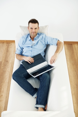 Mature man using laptop at homeの写真素材