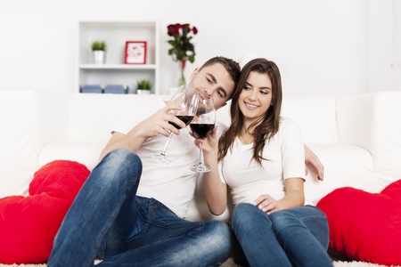 Romantic couple drinking wine at homeの写真素材