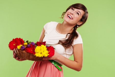 Happy woman in a basket of spring flowersの写真素材