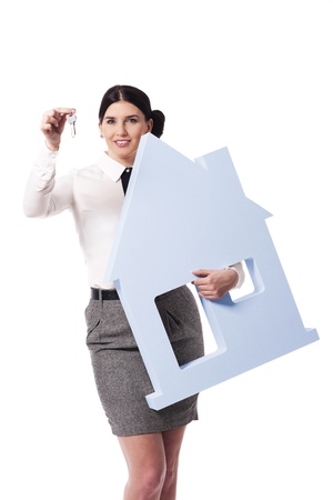 Beautiful businesswoman holding house sign and keys to theの写真素材