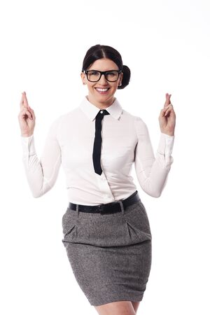 Happy woman wearing glasses with crossed fingersの写真素材