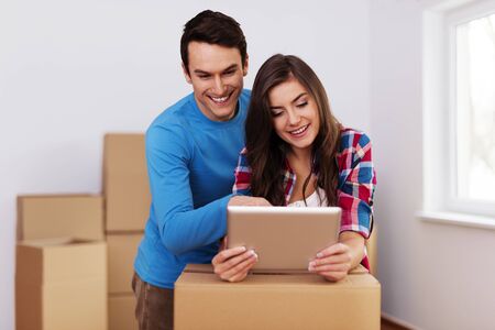 Young and loving couple arranging relocation in new homeの写真素材