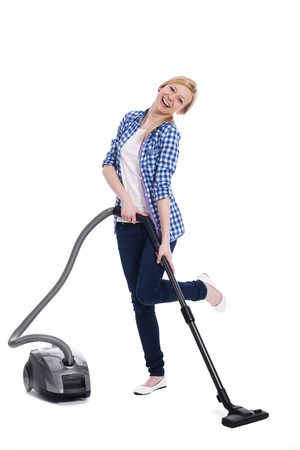 Pretty and smiling woman vacuuming a floorの写真素材