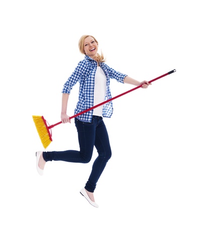 Crazy female cleaner flying with broomstickの写真素材