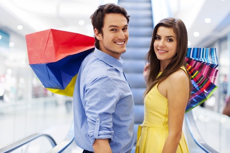 Smiling couple on escalator in shopping mallの写真素材