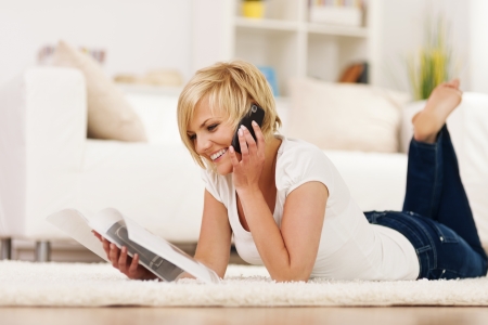 Happy woman ordering something from catalogの写真素材