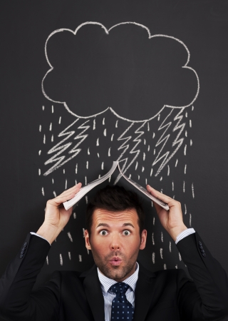 Businessman covering head from rain の写真素材