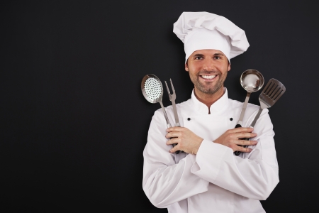 Happy young chef with cooking equipmentの写真素材