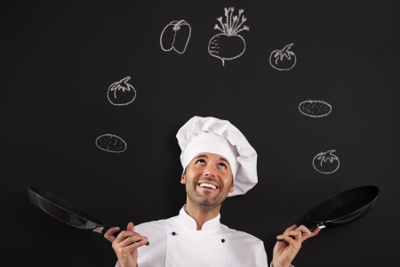 Handsome chef jugglery with vegetableの写真素材