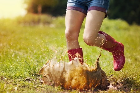 Woman have fun jumping in puddleの写真素材