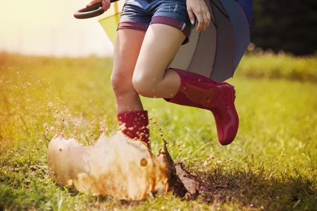 Running woman with umbrella and rubber boots
の写真素材