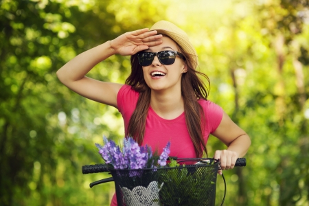 Happy woman with bike watching somethingの写真素材