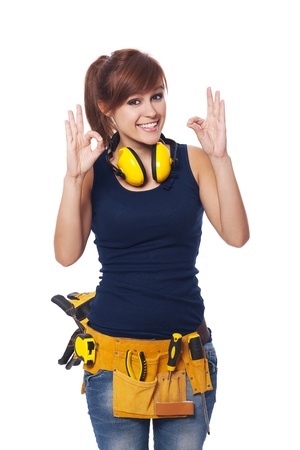 Happy young female construction worker gesturing OK signの写真素材