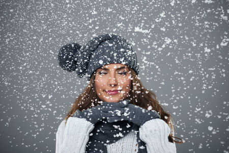 Beautiful young woman enjoys first snow の写真素材