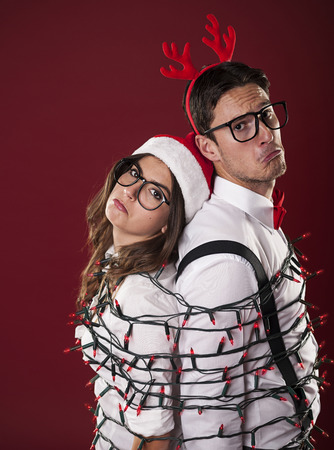 Nerd couple have problems with christmas decorationの写真素材