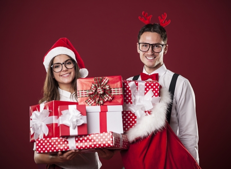 Portrait of smiling couple with stack of christmas presents の写真素材