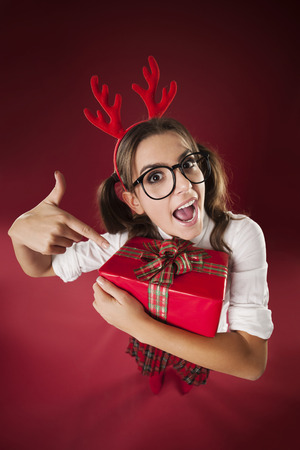 Shocked nerdy woman pointing at christmas gift の写真素材