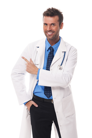 Happy doctor pointing at copy space の写真素材