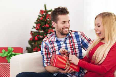Happy couple have fun during the opening christmas presentの写真素材