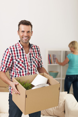 Handsome man unpacking in new home の写真素材