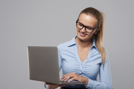Smiling young businesswoman working on slim laptop 
の写真素材