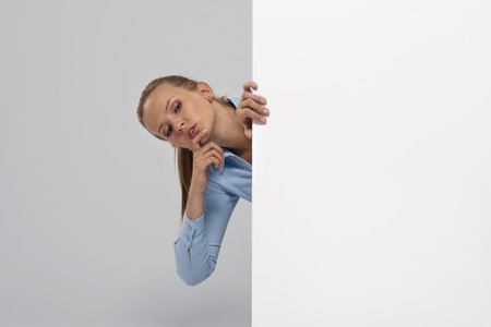 Curious businesswoman peeking at whiteboard
の写真素材