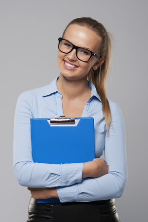 Happy businesswoman holding blue clipboard 
の写真素材