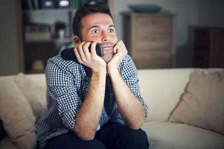 Smiling man watching interesting movieの写真素材