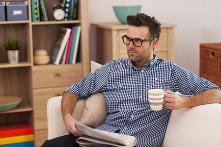 Portrait of focus man with newspaper and cup of coffee の写真素材