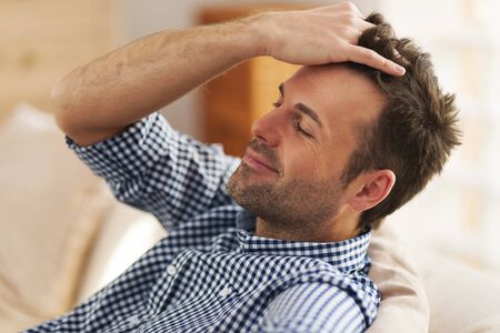 Smiling man with hand in hairの写真素材