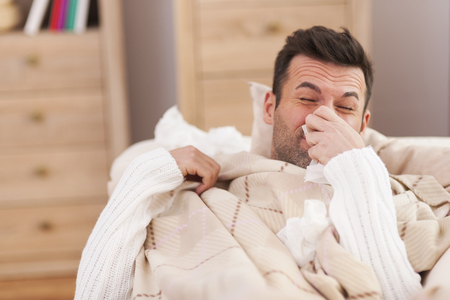 Man blowing his nose in bed
の写真素材