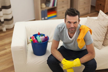 Smiling man with cleaning equipment in living roomの写真素材