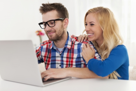 Happy couple browsing something on laptopの写真素材