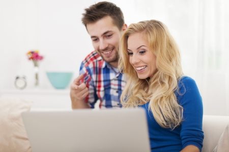 Man showing something on computer his girlfriendの写真素材