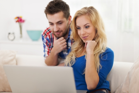 Young couple watching something on computer の写真素材