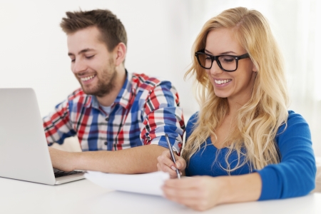 Smiling couple paying bills at homeの写真素材