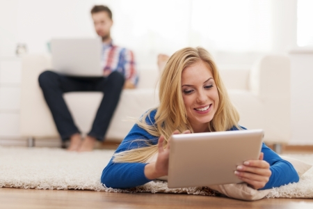 Young couple relaxing at home with electronic equipmentの写真素材