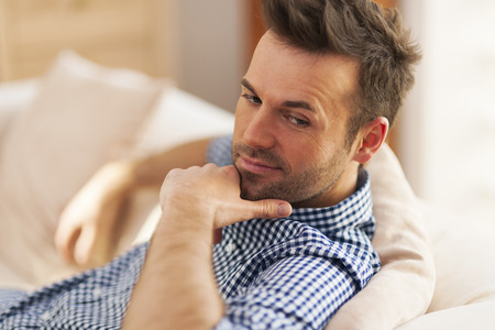 Portrait of handsome man sitting on sofa の写真素材