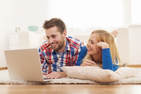 Happy couple surfing the net at home の写真素材