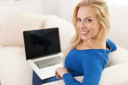 Happy woman using laptop at home の写真素材
