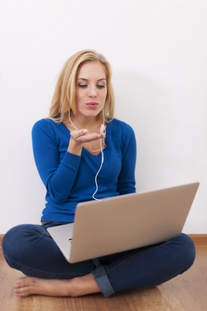Beautiful woman blowing kisses during the conversation by internetの写真素材