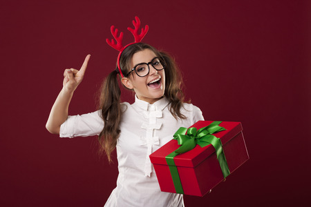 Excited nerdy woman with red christmas presentの写真素材