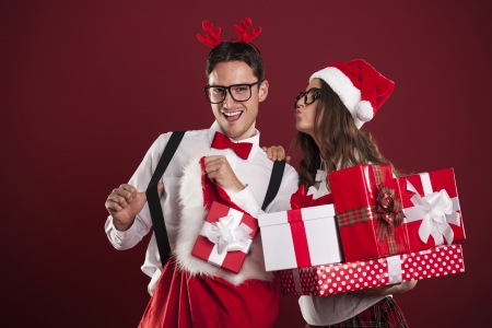 Funny couple with stack of christmas gifts の写真素材