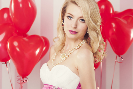 Portrait of alluring woman with balloons in heart shape の写真素材